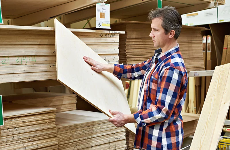 Man inspects surface of plywood