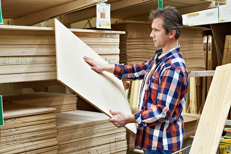 Man choosing plywood flooring from supplier